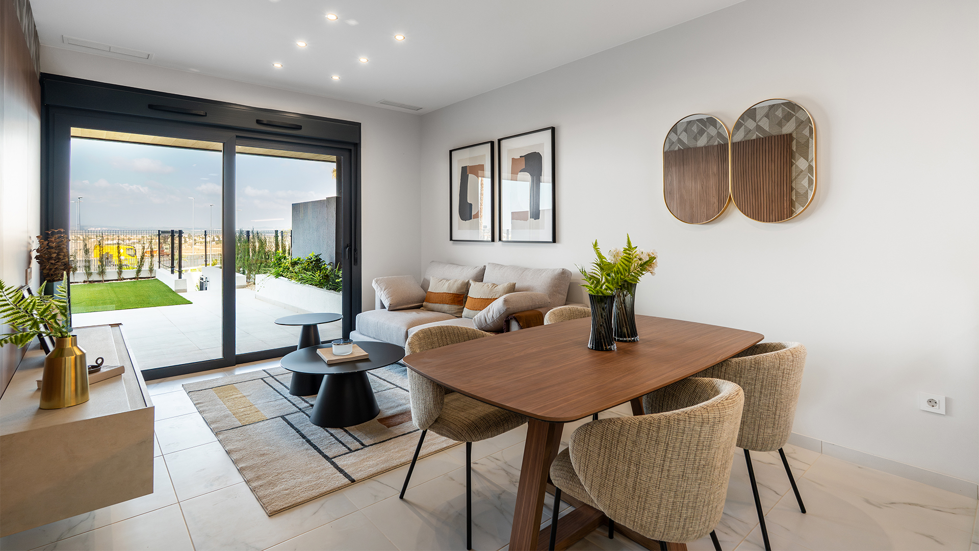 Lichte woonkamer met open keuken en schuifpui naar het terras