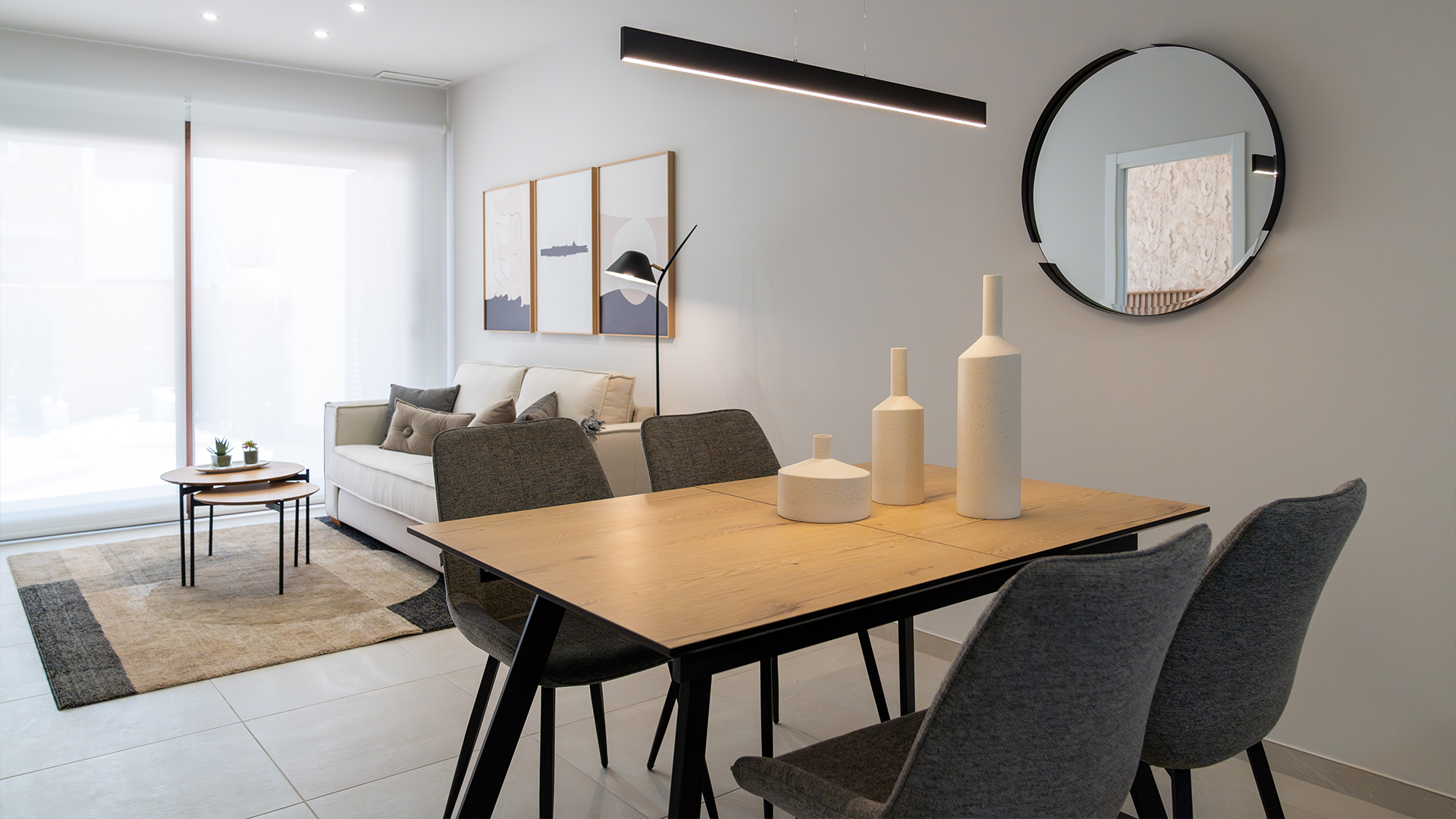 Lichte woonkamer met schuifpuien naar het terras in een modern strandappartement