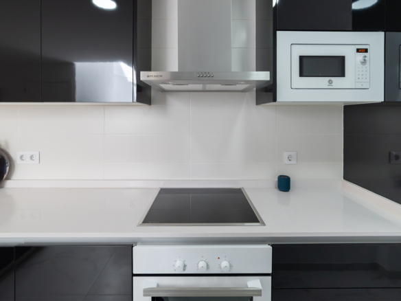 Moderne keuken met inbouwapparatuur in appartement nabij zee