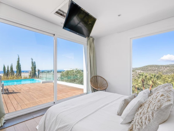 Luxe slaapkamer met dubbele deuren naar privéterras en zeezicht