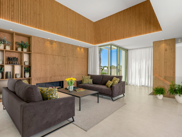 Luxe villa Las Colinas met moderne woonkamer, haard, houten wand en hoge plafonds
