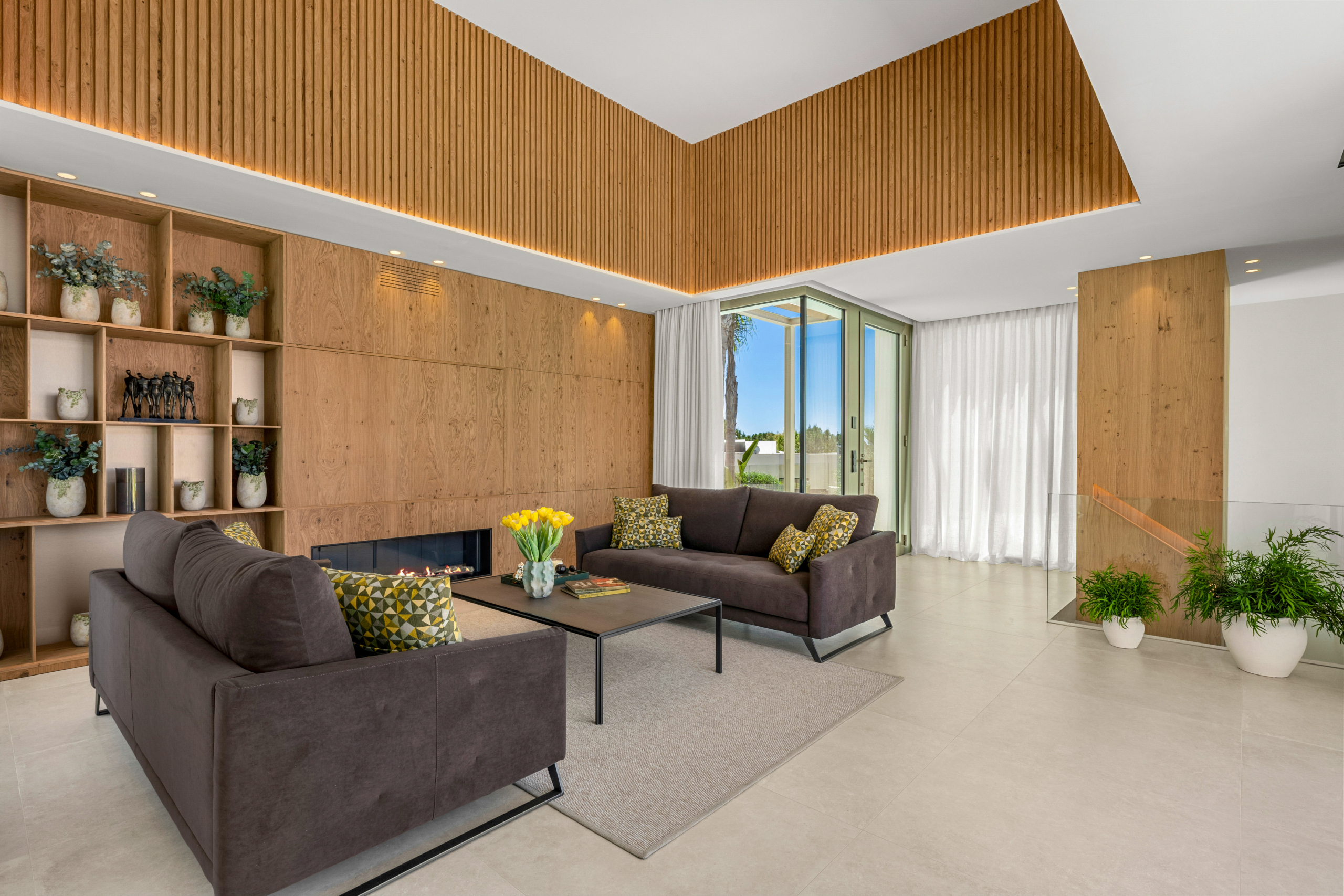 Luxe villa Las Colinas met moderne woonkamer, haard, houten wand en hoge plafonds