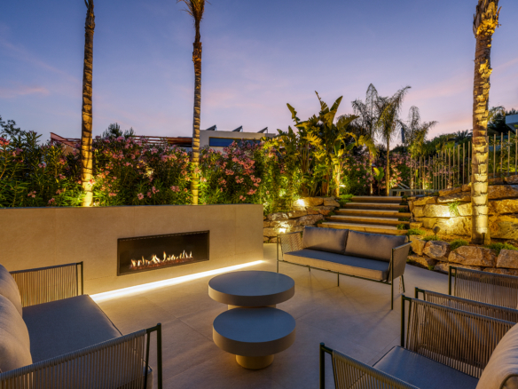 Luxe villa Las Colinas met sfeervolle buitenlounge, haard en verlichte tuin bij zonsondergang