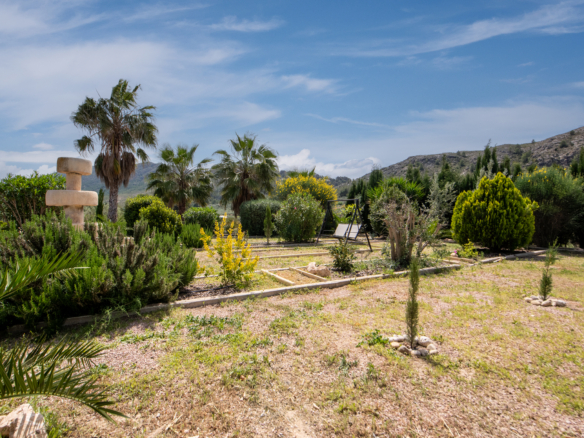 Aangelegde voortuin met volwassen bomen, fontein en mediterrane beplanting bij villa in Calasparra