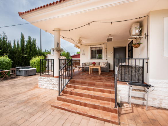 Overdekt terras aan het zwembad met loungehoek en uitzicht op de heuvels van Murcia