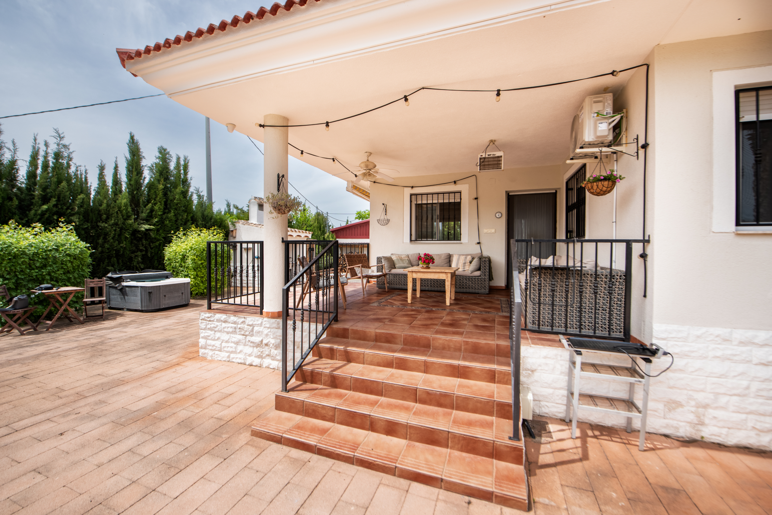 Overdekt terras aan het zwembad met loungehoek en uitzicht op de heuvels van Murcia