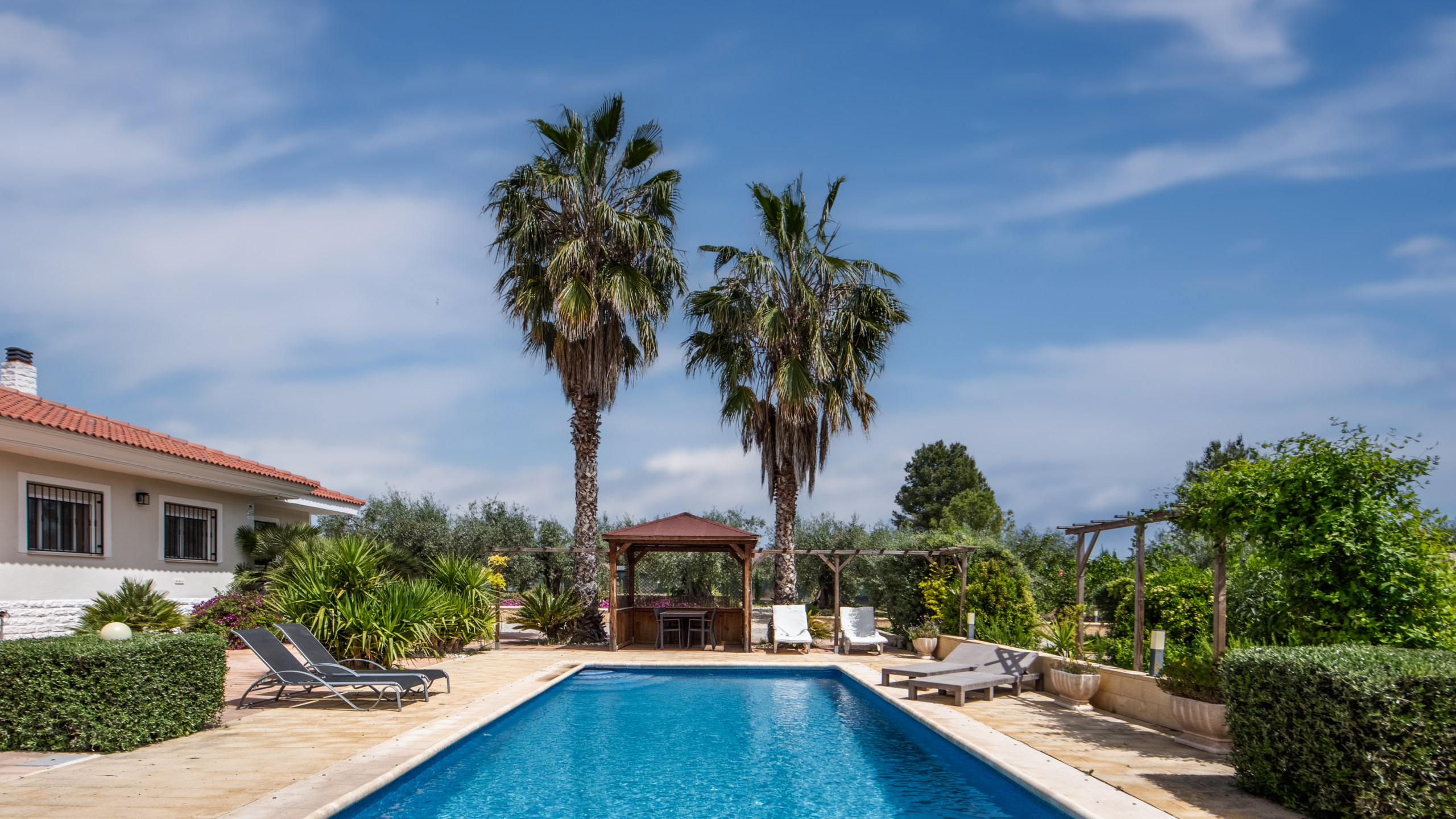 Pergola met mediterrane beplanting rondom het zwembad van villa in Calasparra