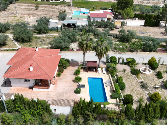 zijaanzicht van de villa met prachtig aangelegde tuin en groot zwembad