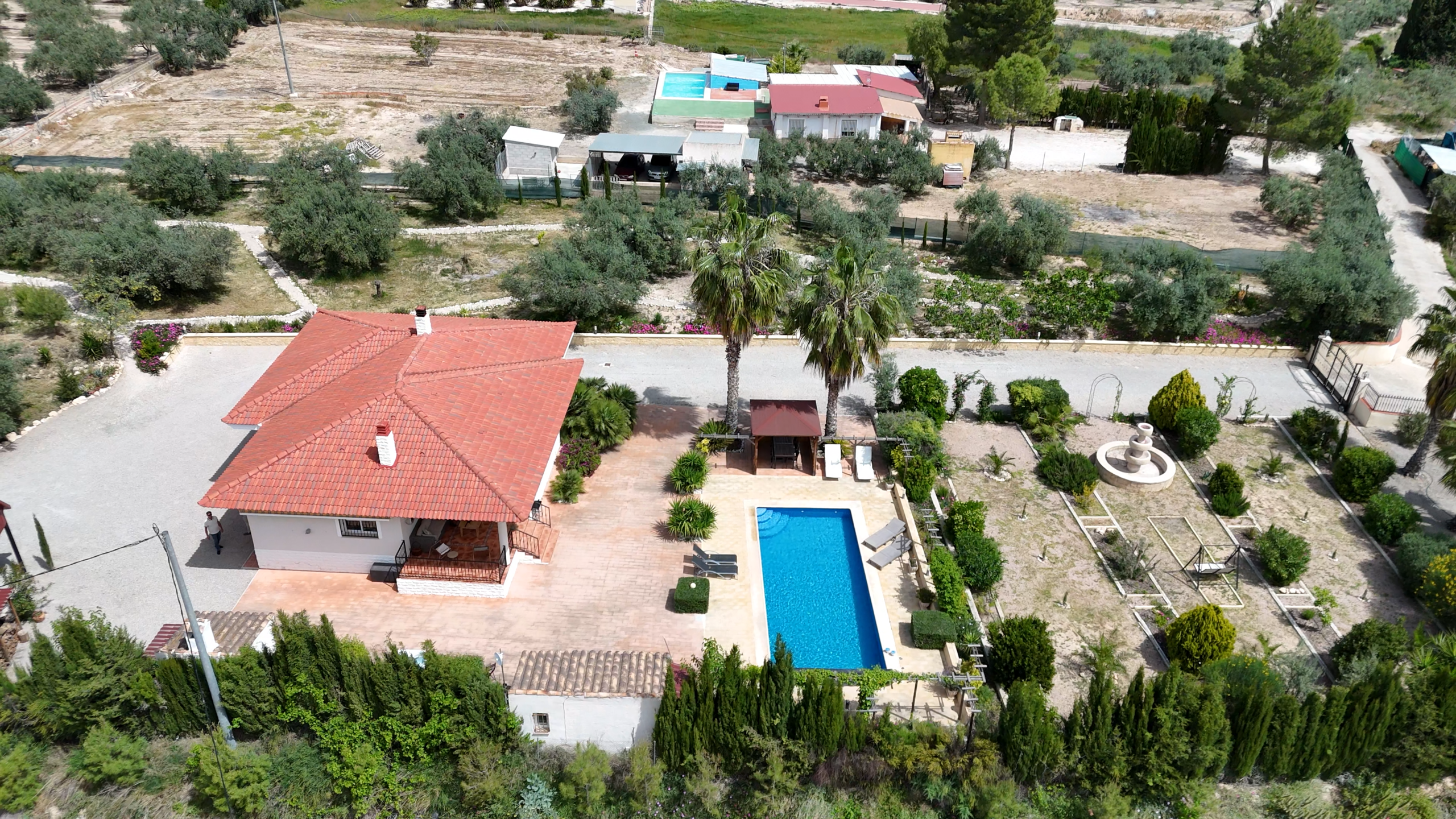 zijaanzicht van de villa met prachtig aangelegde tuin en groot zwembad