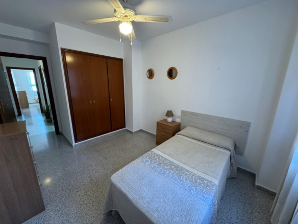 Small bedroom with a single bed, nightstand, and two round wall mirrors above the bed