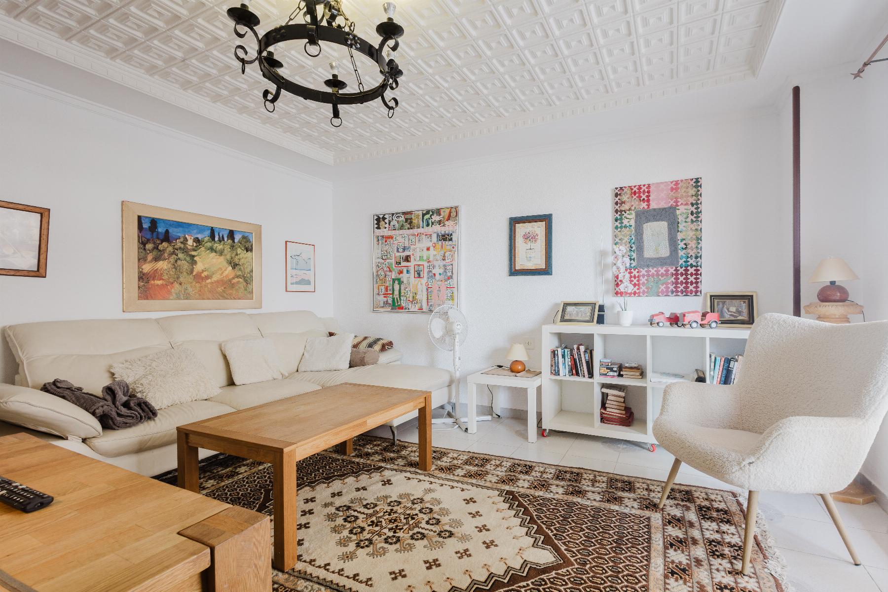 Cozy living room with a beige sectional sofa, wooden coffee tables, and a patterned rug under wall art.