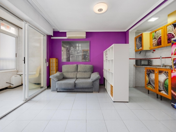 Purple-walled living area with a gray sofa, white cubby shelves, and a black-and-white city print above the sofa.