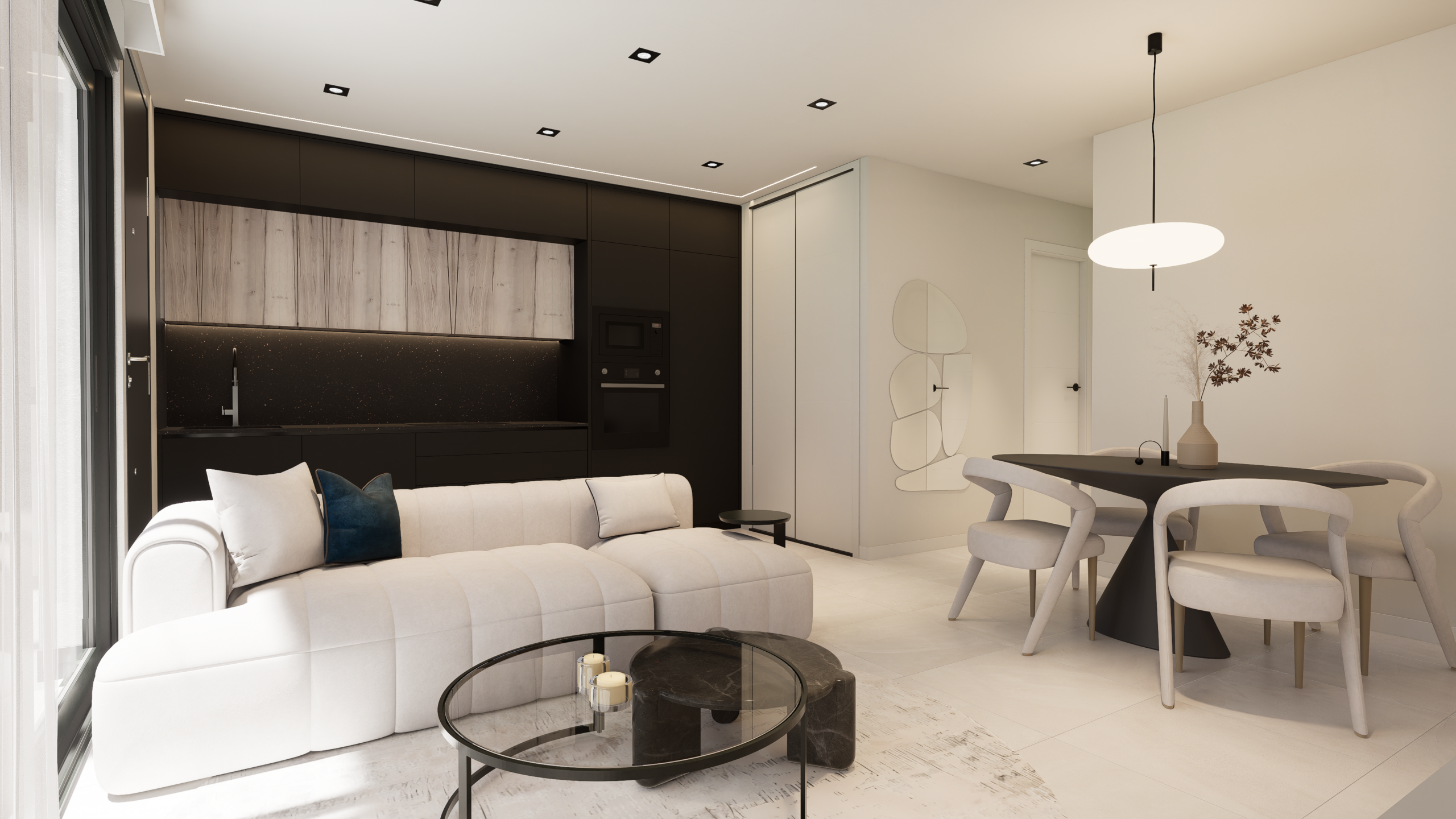 Modern open-concept living space: white sectional sofa, black kitchen cabinets, and a round dining table with beige chairs.