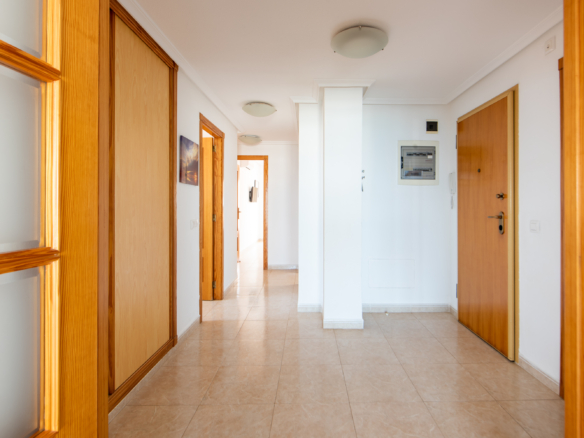 Entreehal van penthouse te koop La Manga in Puerto Mar 3 met ingebouwde kasten en houten deuren