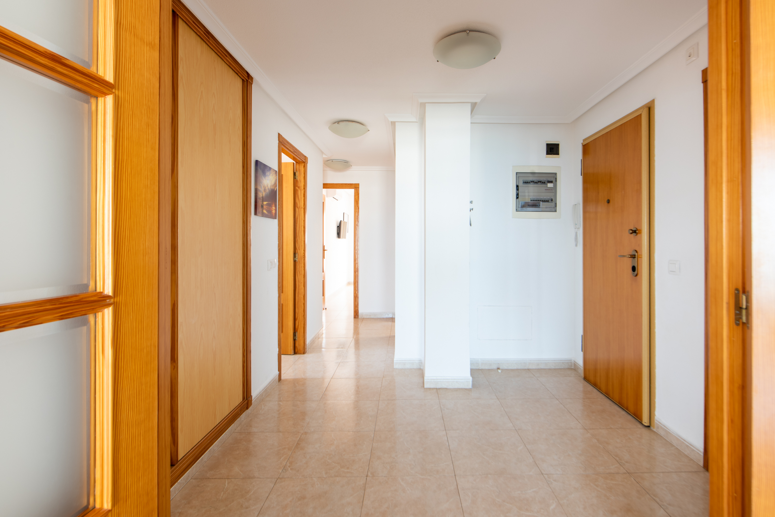 Entreehal van penthouse te koop La Manga in Puerto Mar 3 met ingebouwde kasten en houten deuren
