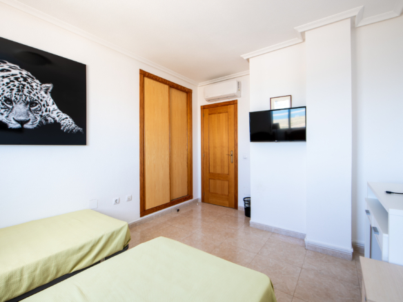 Slaapkamer met ingebouwde kast, airconditioning en televisie in penthouse Puerto Mar 3