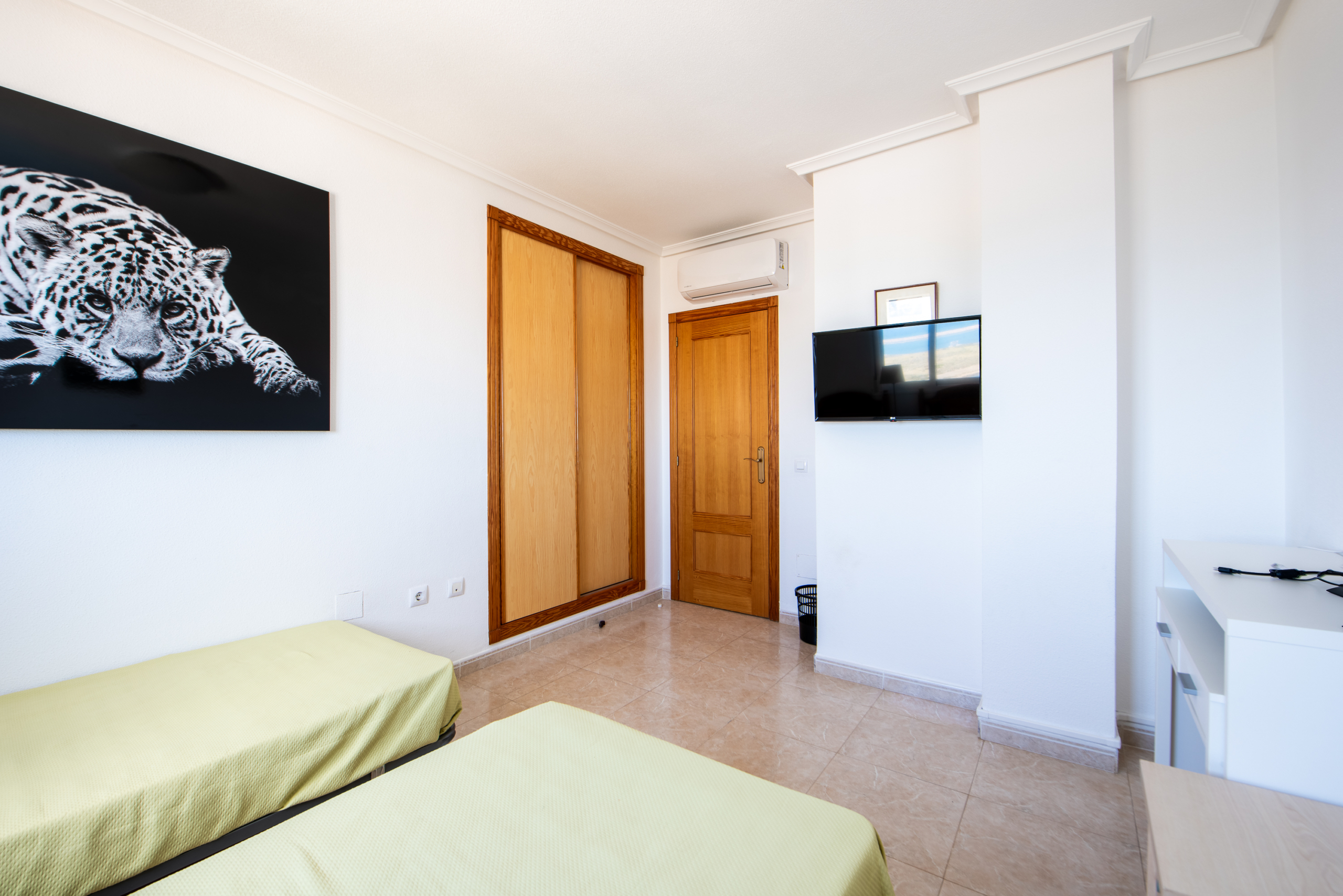 Slaapkamer met ingebouwde kast, airconditioning en televisie in penthouse Puerto Mar 3