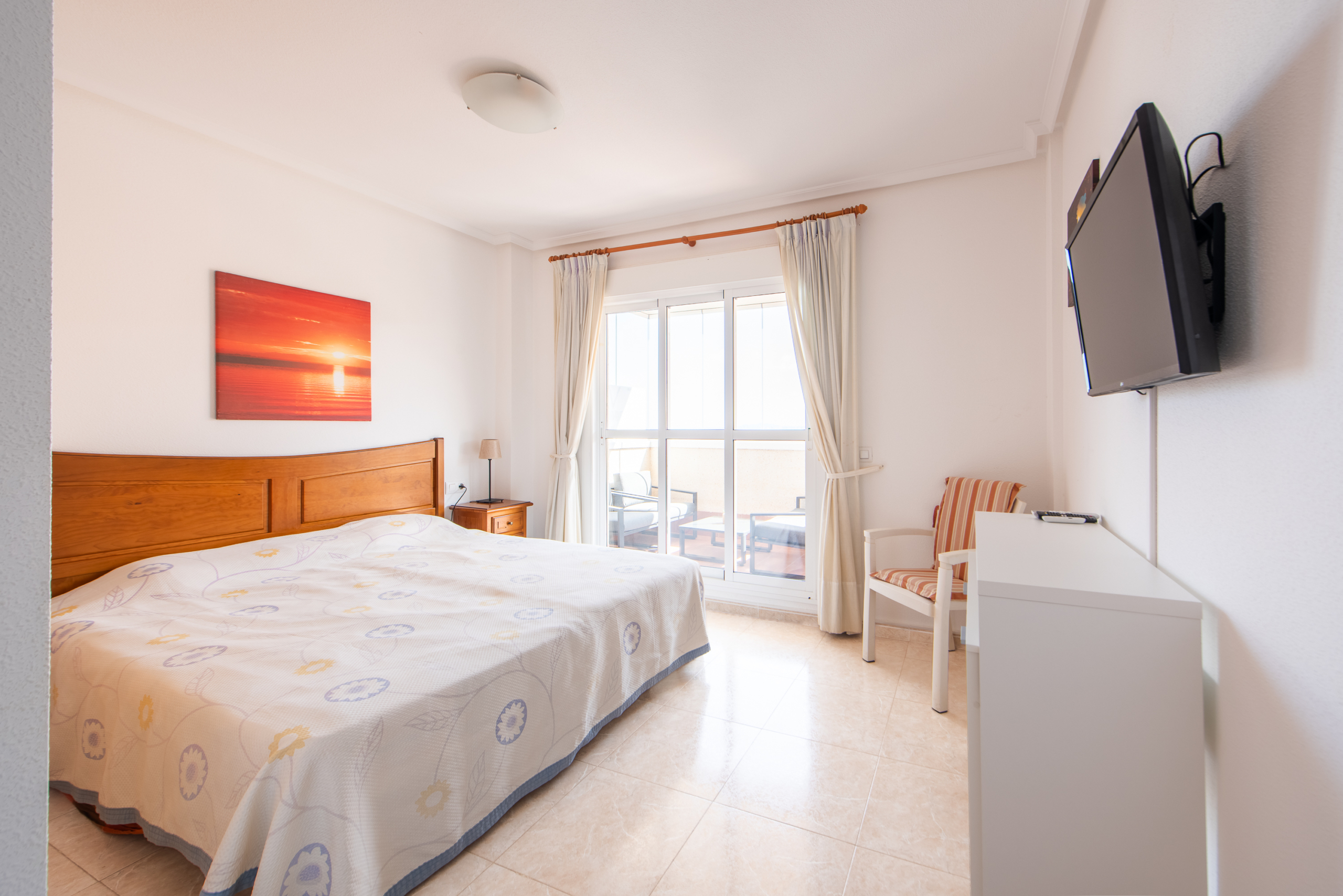 Hoofdslaapkamer met tweepersoonsbed, balkon en veel licht in penthouse Puerto Mar 3