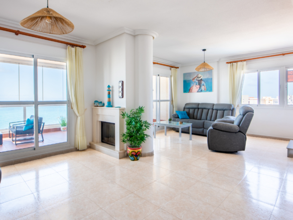 Lichte woonkamer van penthouse in La Manga met doorkijkhaard, grote ramen en uitzicht richting zee