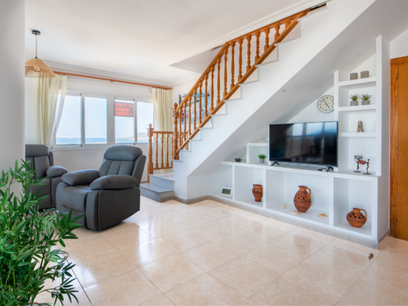 Ruime woonkamer met trap naar dakterras, open keukenbar en doorkijk naar leefruimte in La Manga penthouse