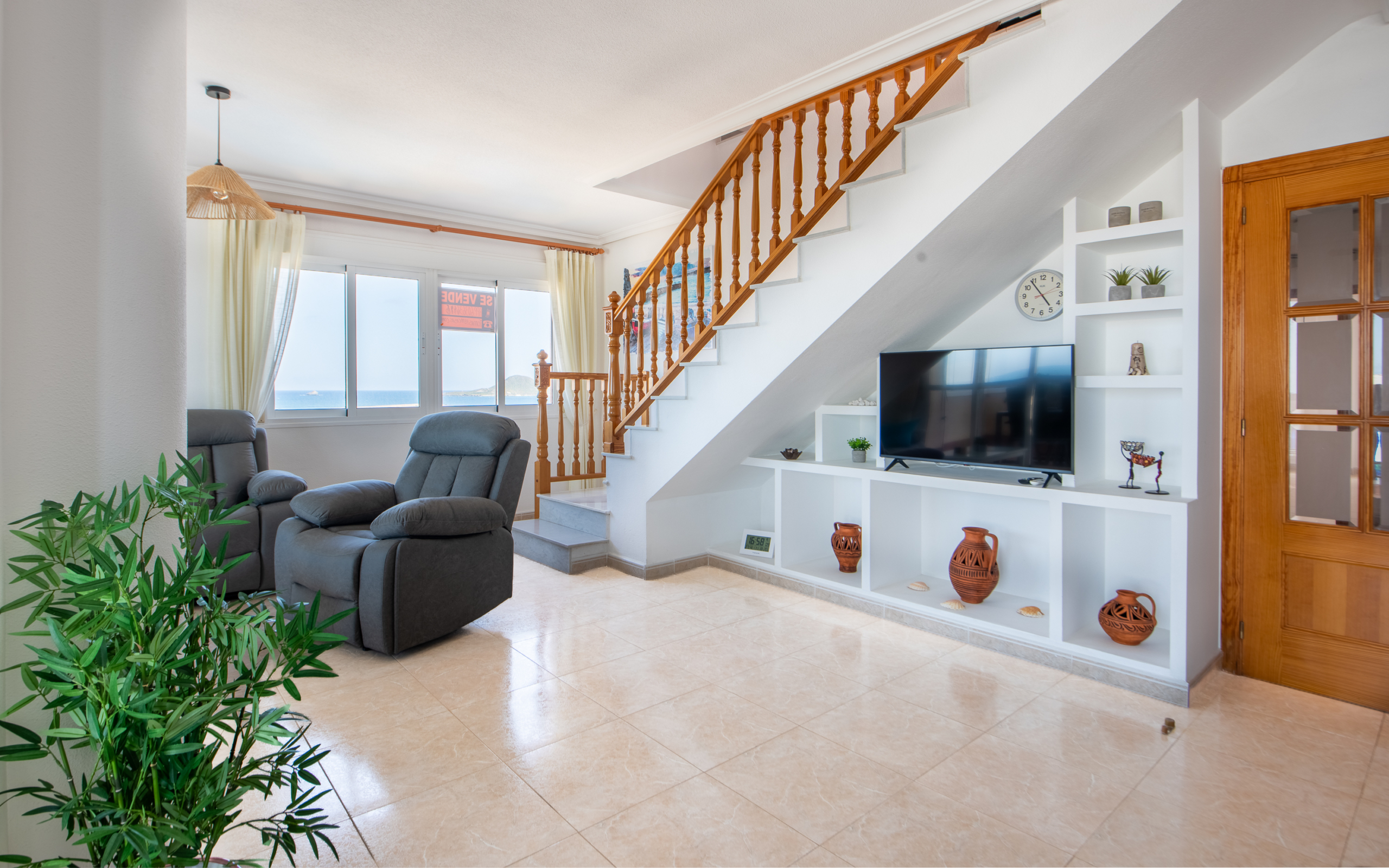Ruime woonkamer met trap naar dakterras, open keukenbar en doorkijk naar leefruimte in La Manga penthouse