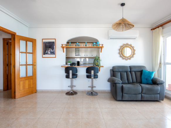 Woonkamer met keukenbar en schuifpui naar balkon in penthouse Puerto Mar 3 La Manga