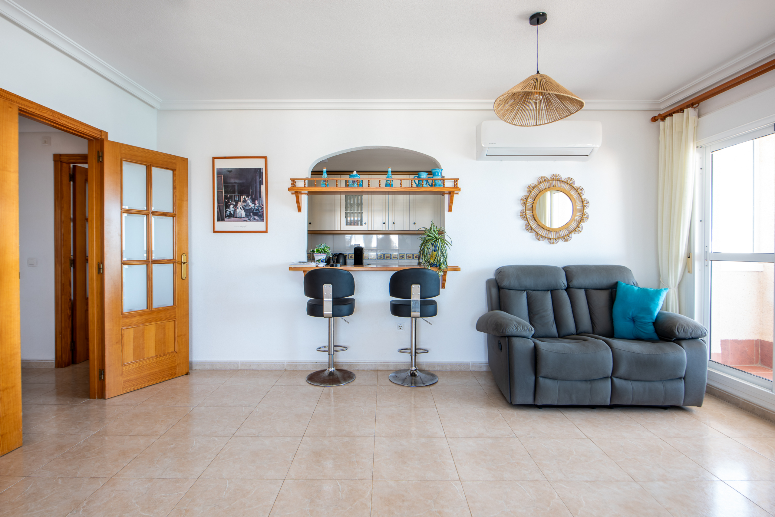Woonkamer met keukenbar en schuifpui naar balkon in penthouse Puerto Mar 3 La Manga