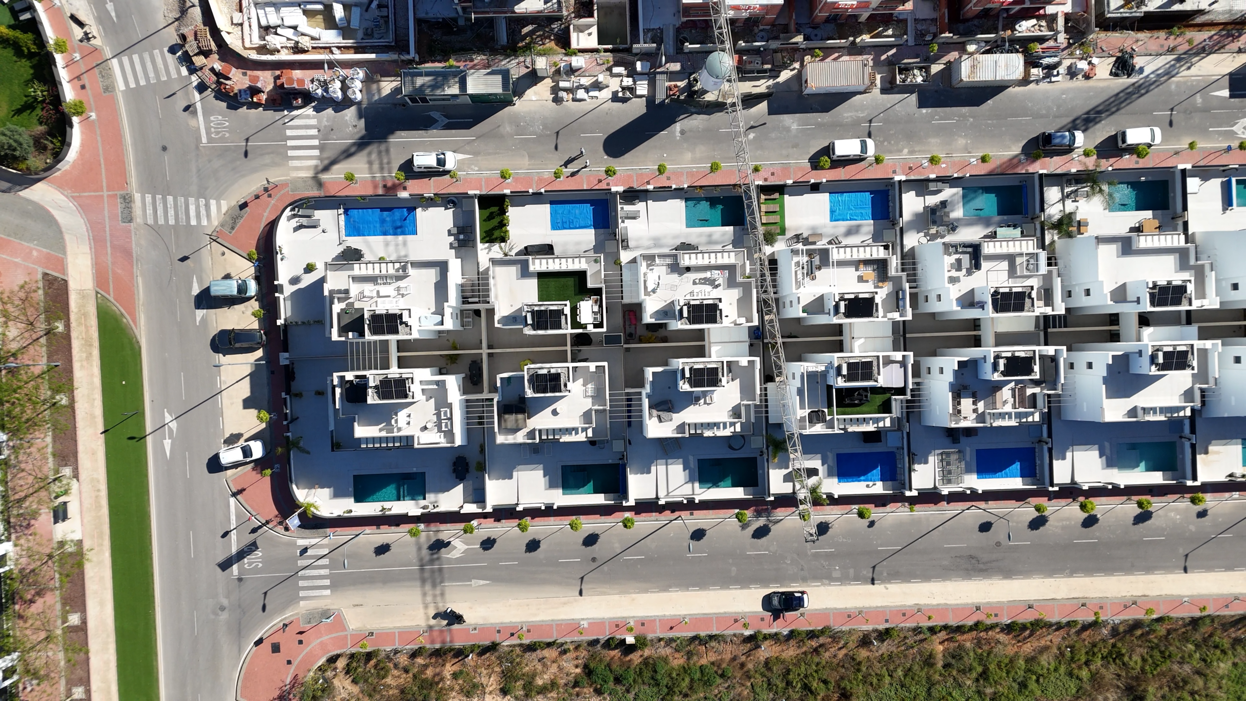 Bovenaanzicht van moderne villa’s in Santa Rosalía met privézwembaden, solariums en zonnepanelen