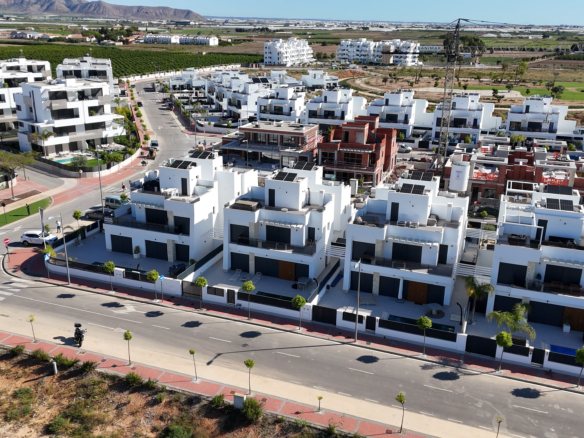 Dronebeeld van nieuwbouw woningen in Santa Rosalía met witte gevels, privéterrassen en zwembaden