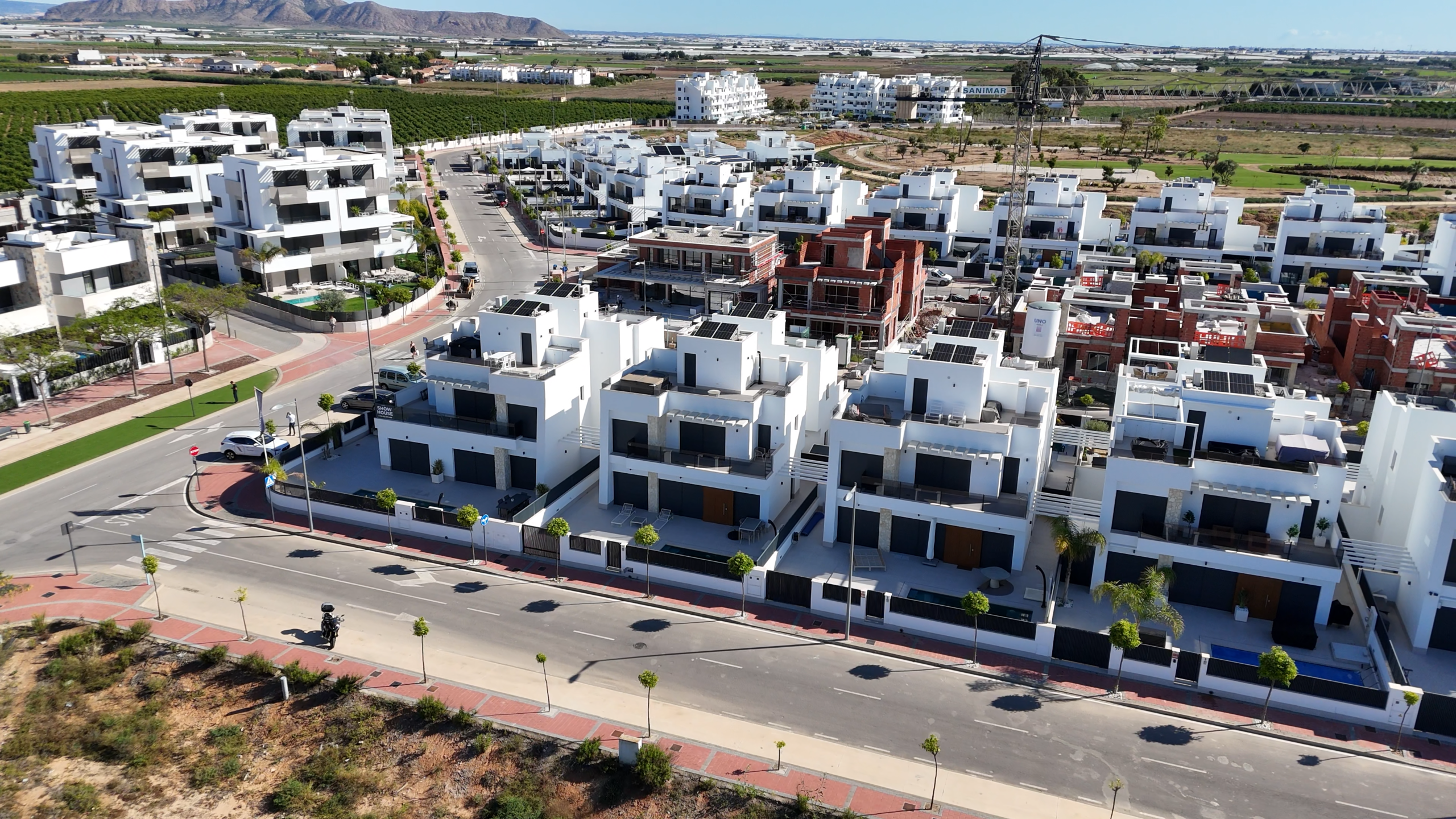 Dronebeeld van nieuwbouw woningen in Santa Rosalía met witte gevels, privéterrassen en zwembaden