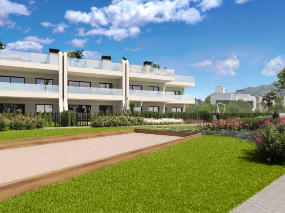 Impressie van de jeu-de-boulesbaan met gazon en bloeiende borders bij nieuwbouw in La Manga Club