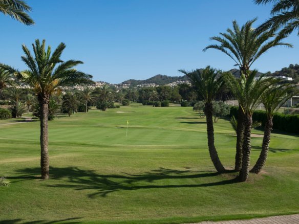Golfbaan met palmbomen en heuvels op de achtergrond, nabij nieuwbouw in La Manga Club