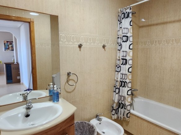 Badkamer met wastafelmeubel, toilet, bidet en ligbad in het huurappartement.