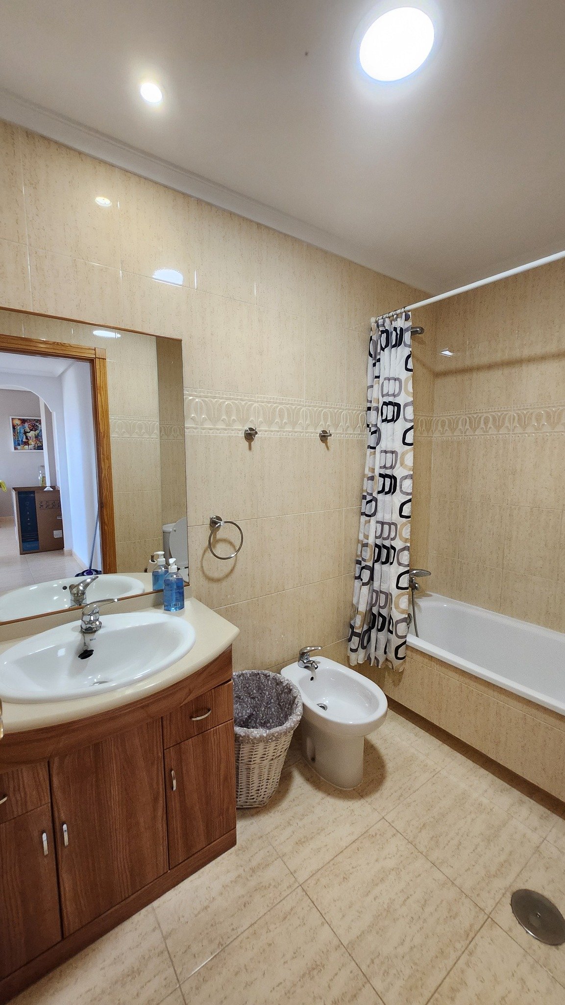 Badkamer met wastafelmeubel, toilet, bidet en ligbad in het huurappartement.