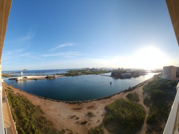 Panoramisch uitzicht over het water vanaf het terras bij avondlicht.