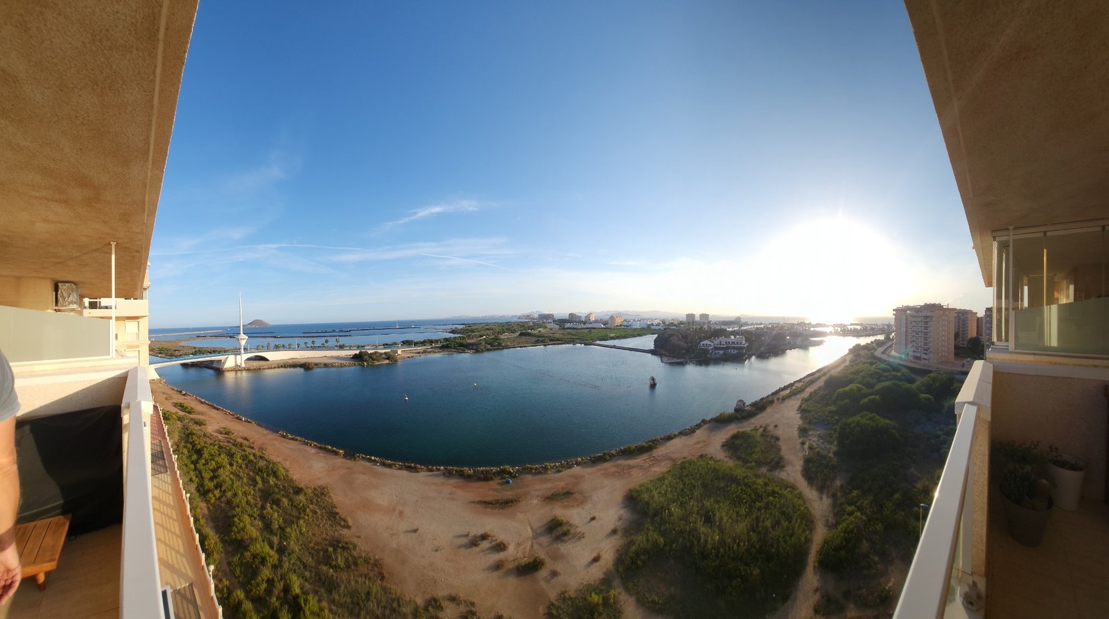 Panoramisch uitzicht over het water vanaf het terras bij avondlicht.
