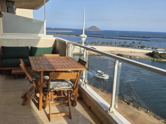 Eettafel en zitplaatsen op het terras met uitzicht over het water.