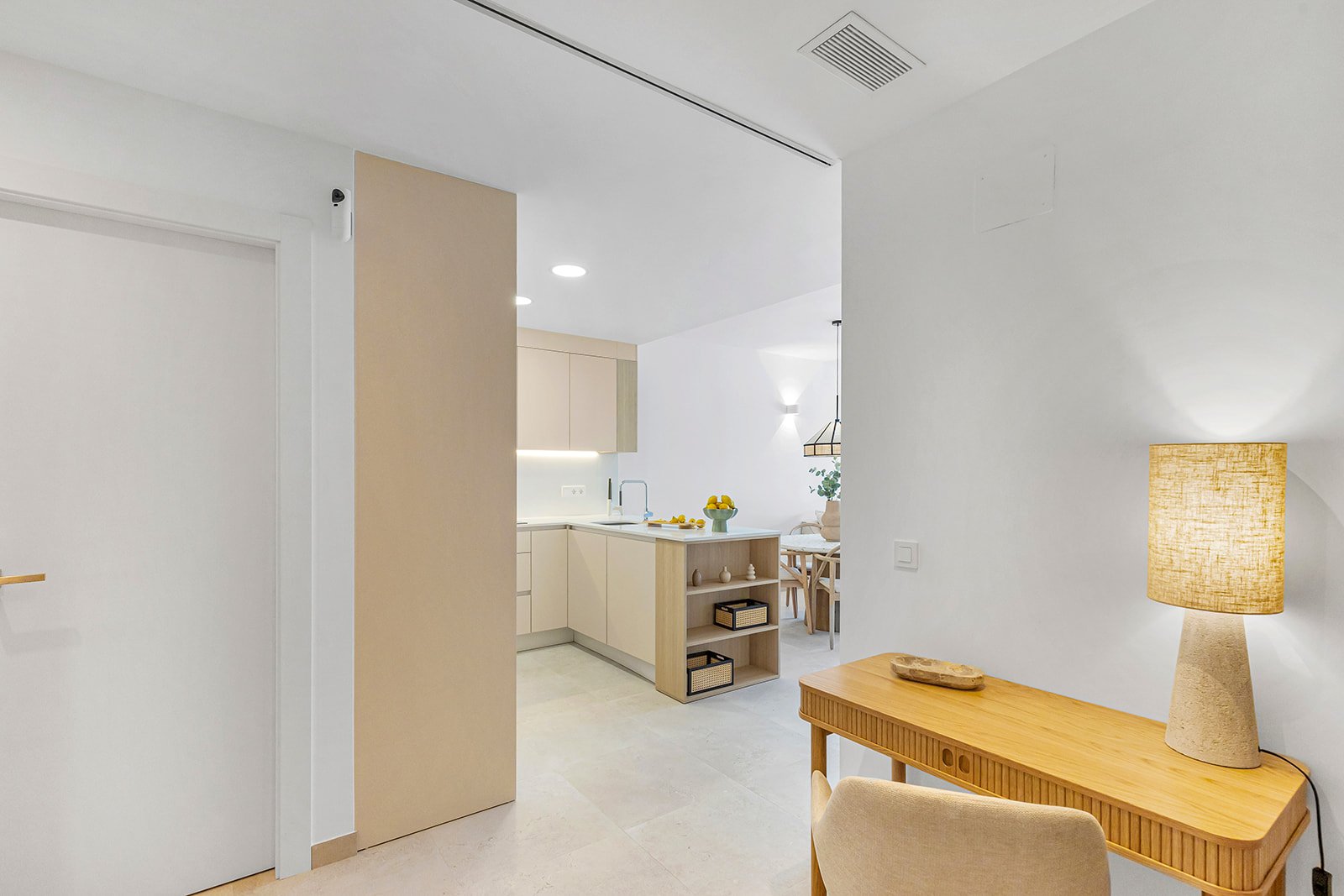 Moderne woonkamer met een bureau en een open keuken.