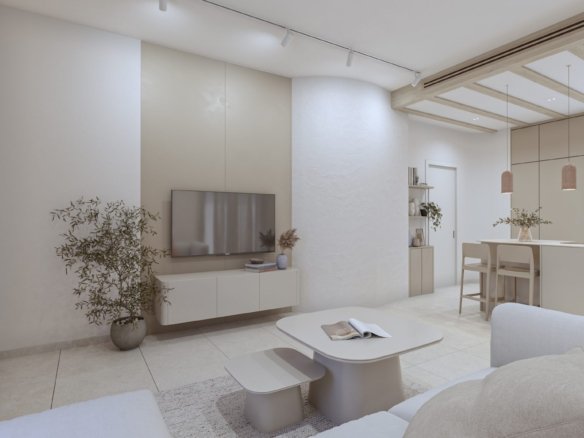 Woonkamer met zithoek, salontafels en televisie, met een keuken en eetbar op de achtergrond.