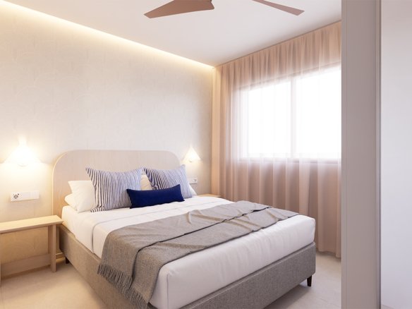 Een slaapkamer met een bed, kussens en een raam achter een gordijn.