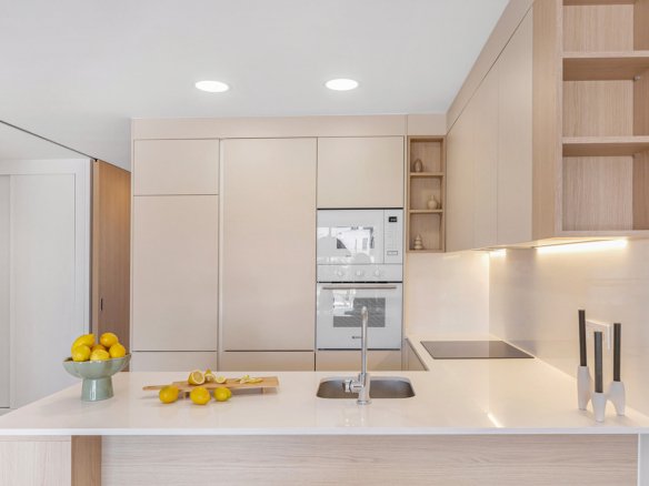 Moderne keuken met aanrecht, kasten en oven zichtbaar.