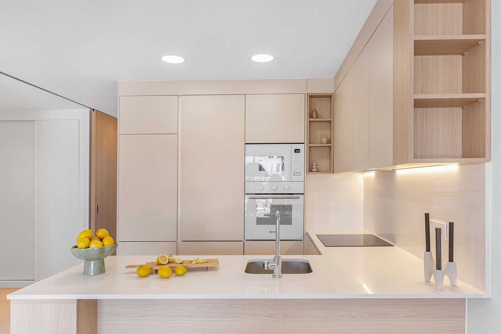 Moderne keuken met aanrecht, kasten en oven zichtbaar.