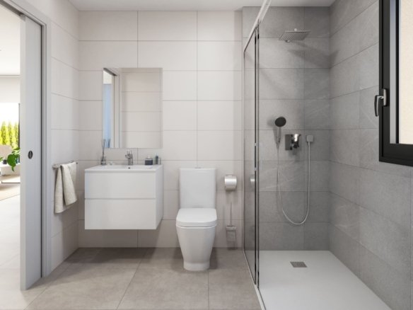 Badkamer met wastafelmeubel, toilet en inloopdouche achter een glazen wand.