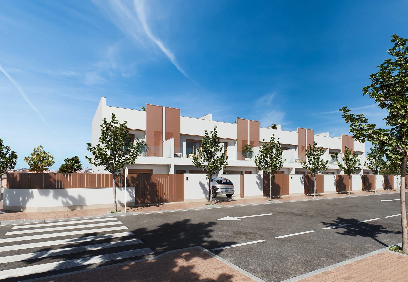 Straatbeeld met een rij moderne woningen, voortuinen achter lage muren en een auto bij een toegang van Geschakelde woning kopen in San Pedro.
