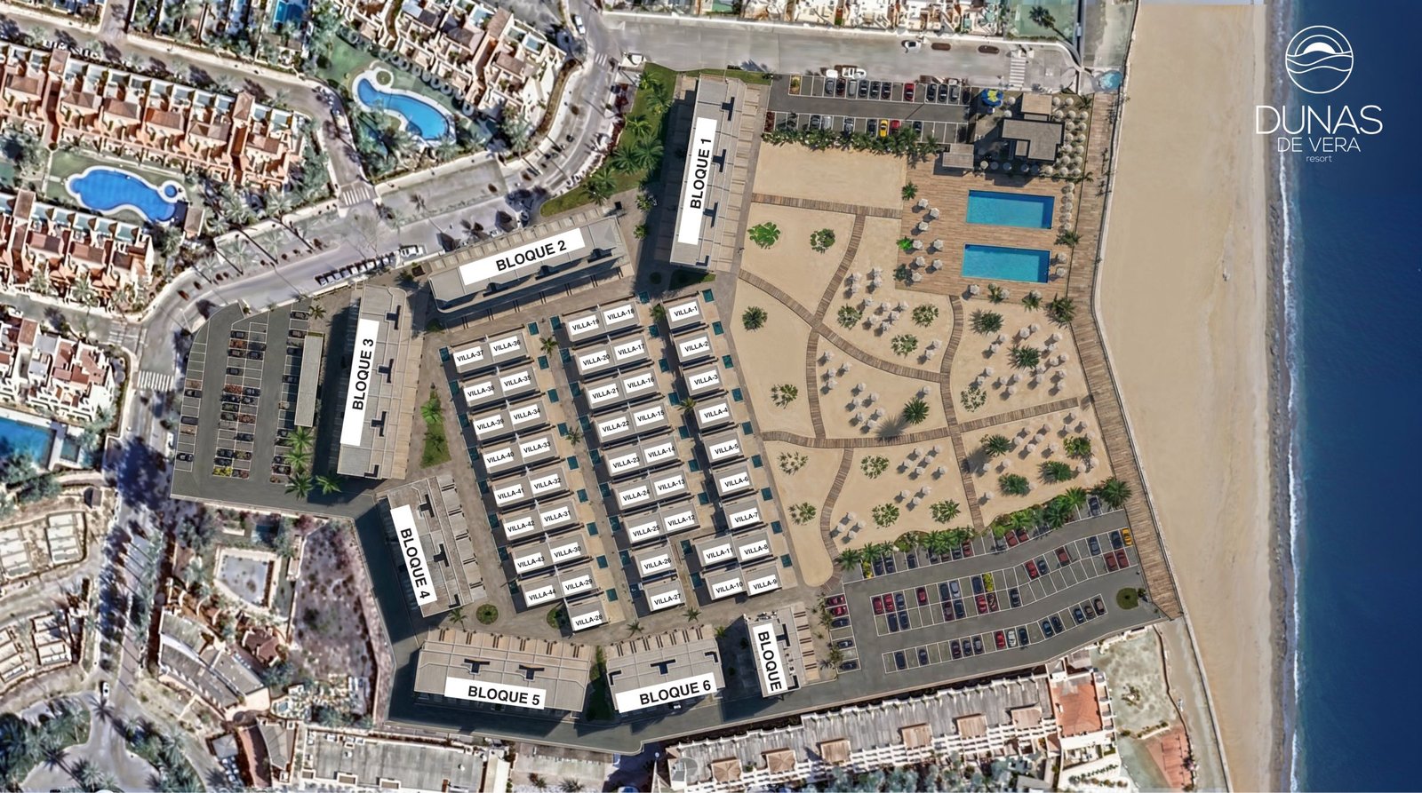 Bovenaanzicht van een kustcomplex met gebouwen, villa’s, zwembaden, parkeerplaatsen en strand.