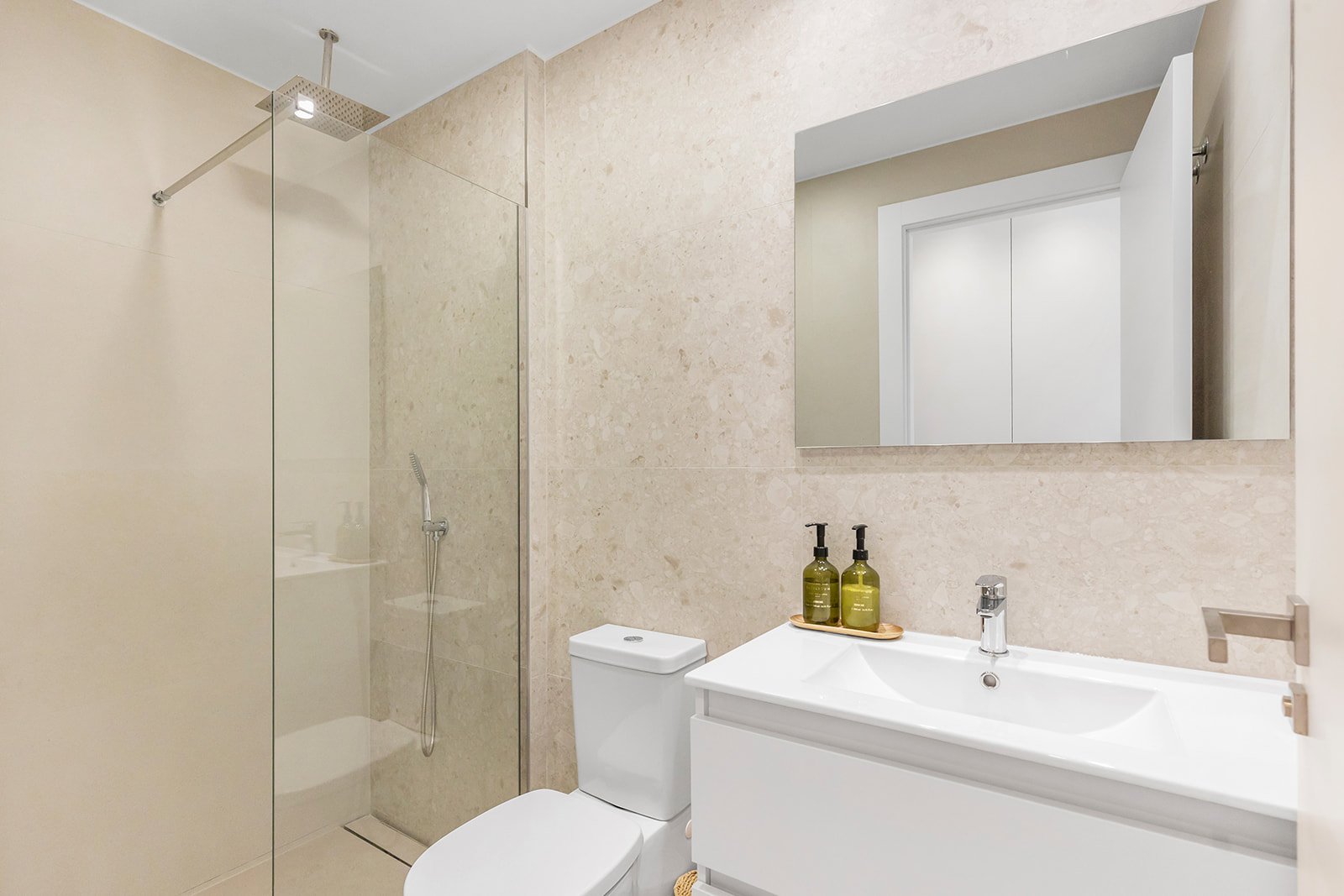 Moderne badkamer met douche, toilet en wastafel.