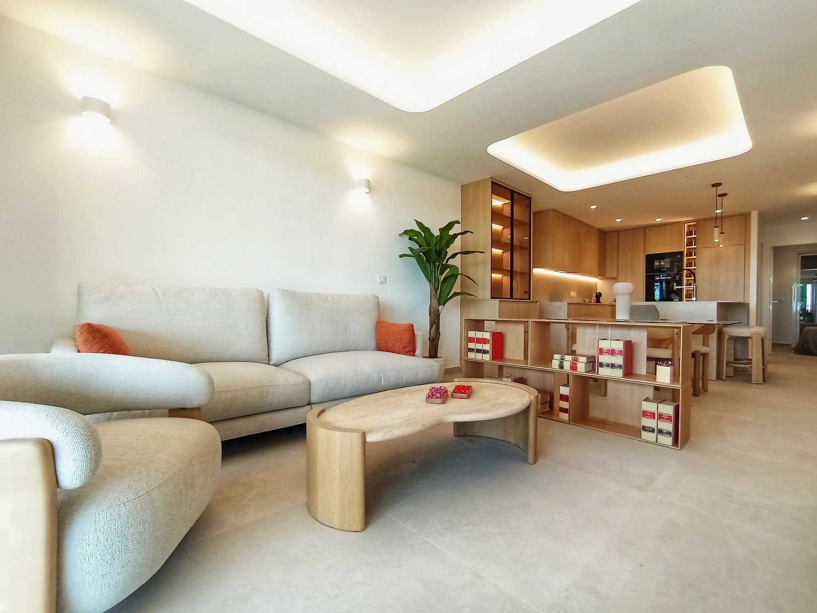 Moderne woonkamer met een open keuken, inclusief een bank, stoelen en een eettafel.