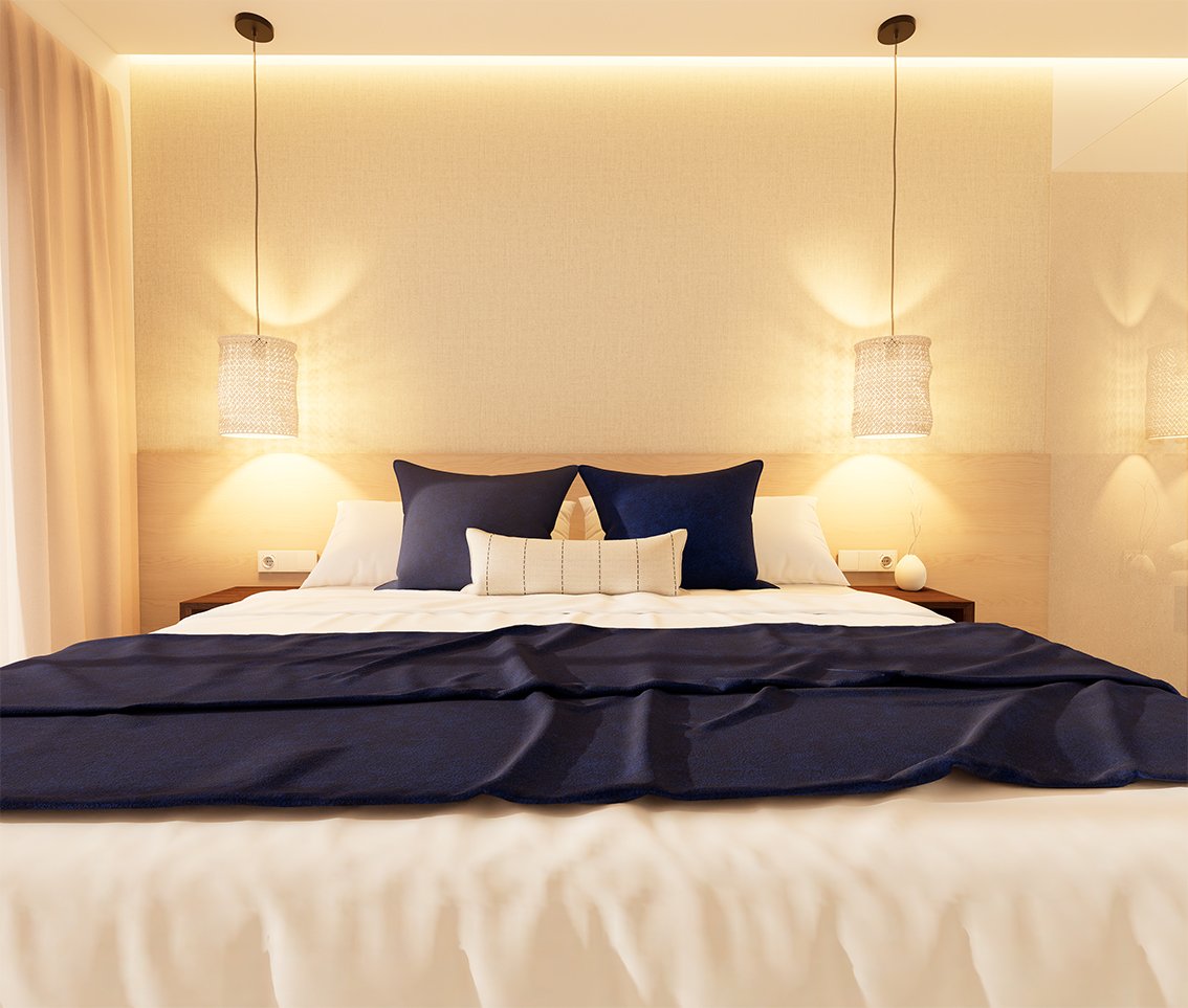 Slaapkamer met bed, blauwe kussens en hanglampen.