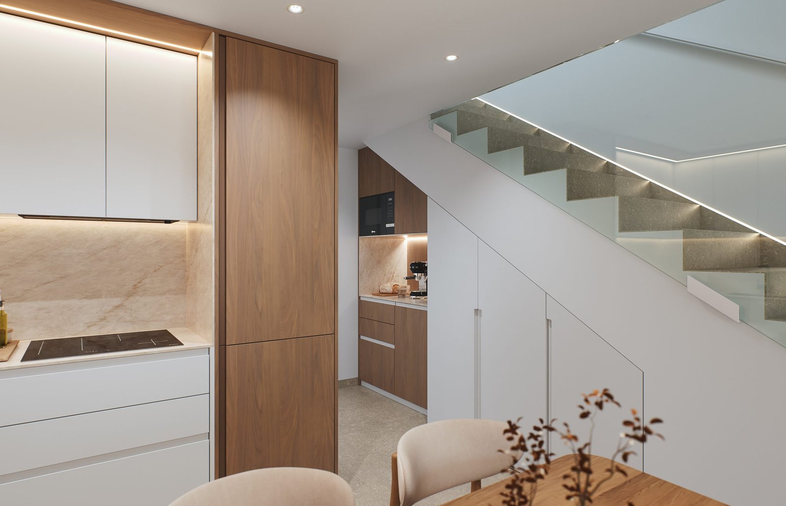 Moderne keuken met kookplaat en kasten naast een trap met glazen balustrade.