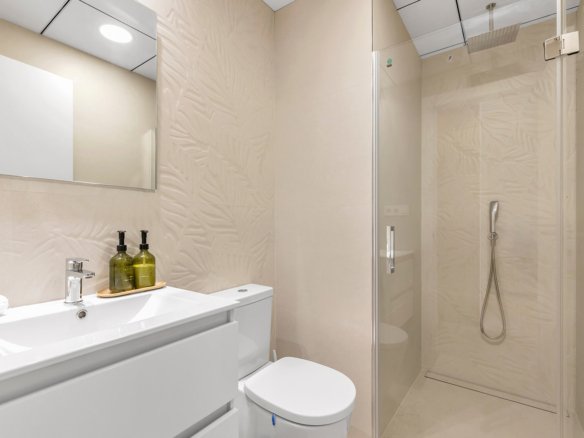 Moderne badkamer met douche, wastafel en toilet.